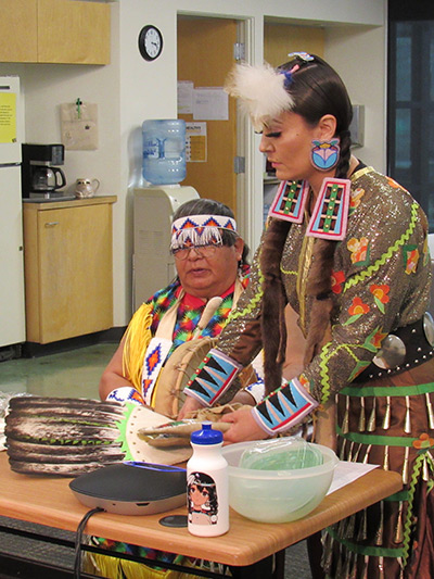 Two members of the Nez Perce tribe showing different cultural items during an online art ability workshop.