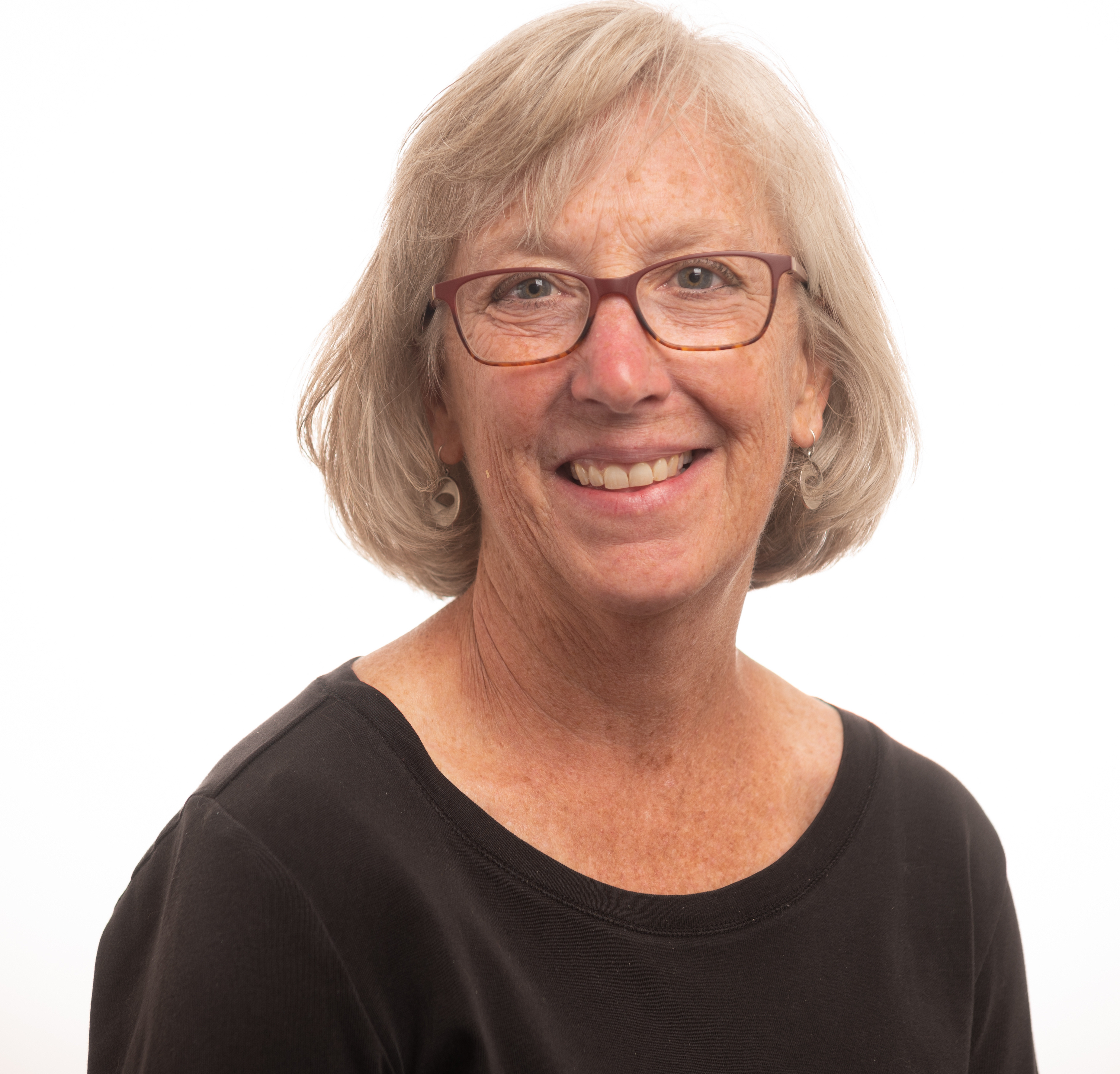 Middle-aged caucasian woman with mid-neck length blonde hair wearing glasses and a black shirt
